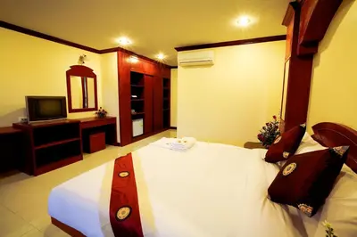 a bedroom with a large bed and a television at Baan Sudarat Hotel in Patong Beach