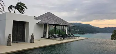 a group of chairs sitting next to a swimming pool at Villa Princess Stephanie in Kata Beach