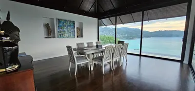 a dining room with a table and chairs with a view at Villa Princess Stephanie in Kata Beach
