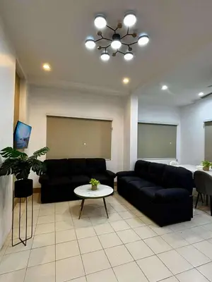 a living room with a black couch and a table at The Villa Residences Resort in Patong Beach