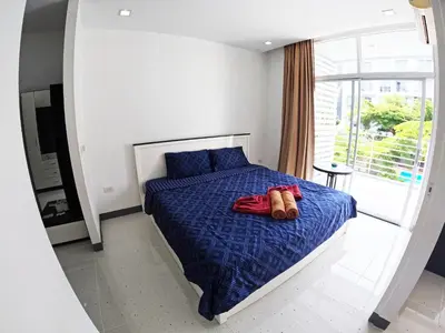 a bedroom with a bed with a pair of shoes on it at At Seacondo-Excellent-B26 in Klong Muang Beach
