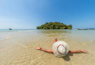 a person laying in the water on a beach at At Seacondo-1 Bedroom-A12 in Klong Muang Beach