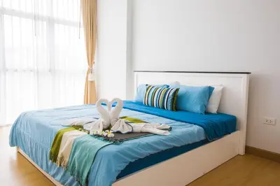 a bedroom with a bed with towels andippers on it at At Seacondo-1 Bedroom-A25 in Klong Muang Beach