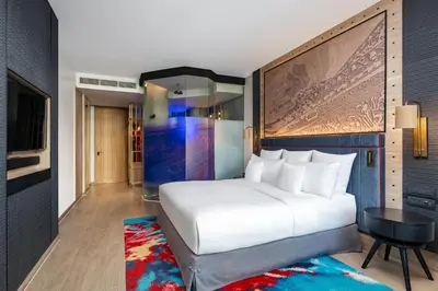 a bedroom with a large white bed and a table at Hotel Indigo Phuket Patong by IHG in Patong Beach