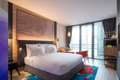 a bedroom with a large white bed and a table at Hotel Indigo Phuket Patong by IHG in Patong Beach
