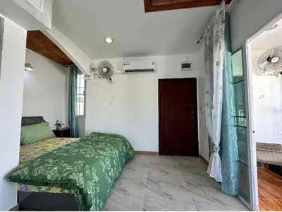 a bedroom with a green bed and a door at 3BR Villa near Laguna beach in Bang Tao Beach