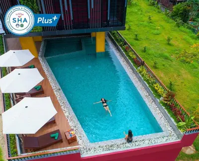 two people swimming in a pool at a resort at Le Resort and Villas in Rawai Beach