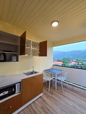 a kitchen with a sink and a table with chairs at Baan Rosa Bangtao Beach in Bang Tao Beach