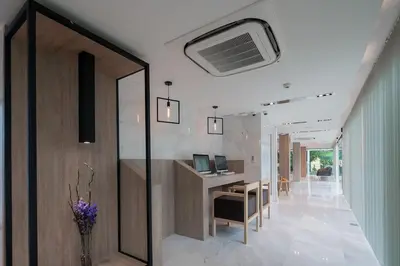 a hallway of a house with a desk and a table at The Beachfront Hotel Phuket in Rawai Beach