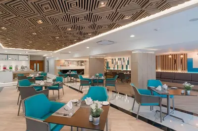 a dining room with blue chairs and tables at The Beachfront Hotel Phuket in Rawai Beach