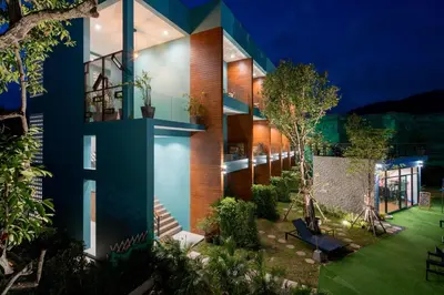 a house with a blue facade with a garden at Peace Blue Naiharn Naturist Resort Phuket SHA Extra Plus in Rawai Beach