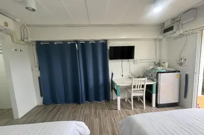 a room with a table and a blue curtain at Tann Anda Resort in Thalang