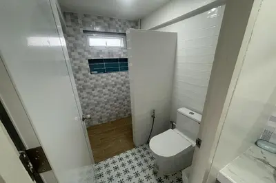 a small bathroom with a toilet and a window at Tann Anda Resort in Thalang