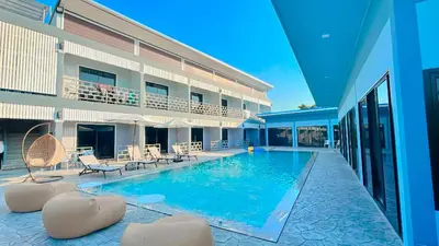 a swimming pool in front of a building at Bests Village & Villa - Chalong Bay Phuket in Chalong