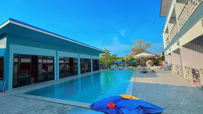 a swimming pool next to a building at Bests Village & Villa - Chalong Bay Phuket in Chalong