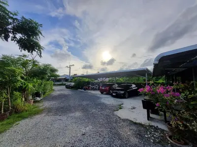 a gravel driveway with cars parked in a parking lot at Bests Village & Villa - Chalong Bay Phuket in Chalong