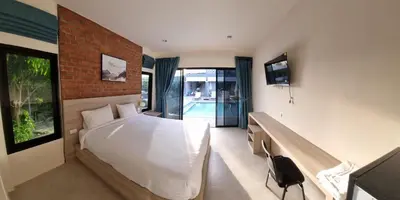 a bedroom with a bed and a desk and a tv at Bests Village & Villa - Chalong Bay Phuket in Chalong