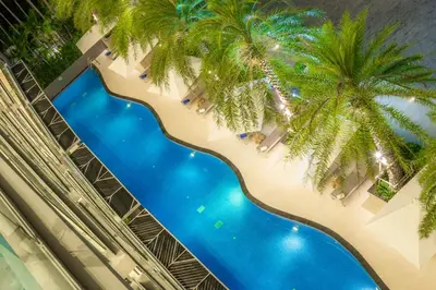 an overhead view of a pool with palm trees on a building at Babylon Sky Garden in Rawai Beach
