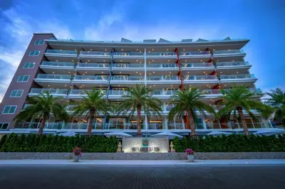 a large building with palm trees in front of it at Babylon Sky Garden in Rawai Beach