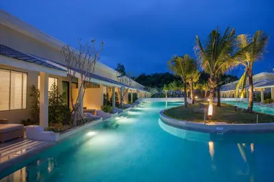 a swimming pool in a resort at night at CRAFT Resort & Villas, Phuket Town - scheduled shuttle to Phuket Old Town in Phuket Town