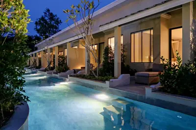 a swimming pool in front of a house at night at CRAFT Resort & Villas, Phuket Town - scheduled shuttle to Phuket Old Town in Phuket Town