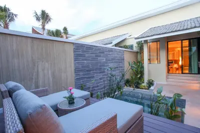a patio with a couch and a table at CRAFT Resort & Villas, Phuket Town - scheduled shuttle to Phuket Old Town in Phuket Town