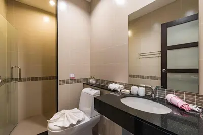 a bathroom with a sink and a toilet and a mirror at Trixie Town House 2 With Private Pool in Rawai Beach