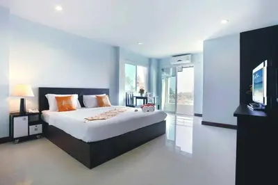 a bedroom with a large bed and a television at Raya Rawai Place in Rawai Beach