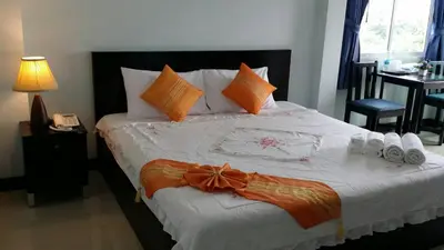 a bedroom with a large bed with orange pillows at Raya Rawai Place in Rawai Beach