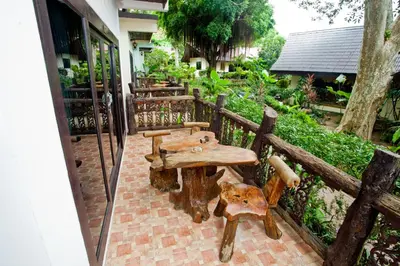 a wooden table and benches on a patio at Paradise Pearl Bungalows in Phi Phi Don
