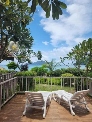 two chairs on a deck with a view of the ocean at Paradise Pearl Bungalows in Phi Phi Don