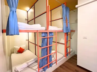 a room with bunk beds in a dorm room at Sleepy Station Hostel in Kata Beach