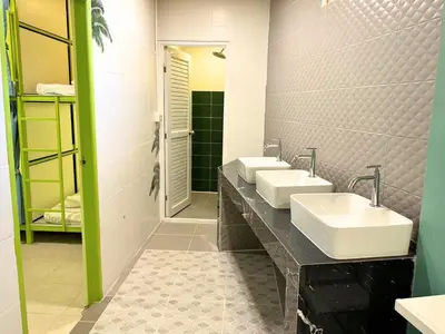 a bathroom with two sinks and a mirror at Sleepy Station Hostel in Kata Beach