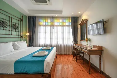 a hotel room with a bed and a desk at WOO Gallery & Boutique hotel in Phuket Town