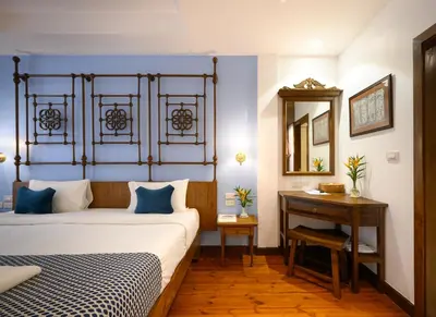 a bedroom with a bed and a table and a mirror at WOO Gallery & Boutique hotel in Phuket Town