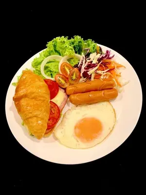 a plate of food with an egg and vegetables at WOO Gallery & Boutique hotel in Phuket Town