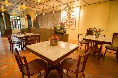 a restaurant with tables and chairs in a room at WOO Gallery & Boutique hotel in Phuket Town