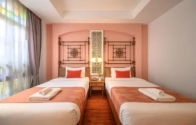 two beds sitting next to each other in a room at WOO Gallery & Boutique hotel in Phuket Town