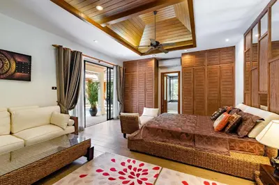 a bedroom with a bed and a couch at Champagne Villa Luxurious Tropical Pool Villa in Rawai Beach