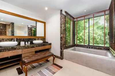 a bathroom with a tub and two sinks and a large window at Champagne Villa Luxurious Tropical Pool Villa in Rawai Beach