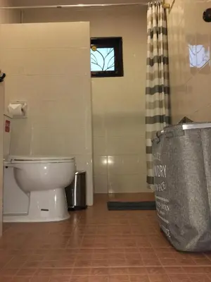 a bathroom with a toilet and a shower with a window at Beautiful 3 Bedroom Garden Villa in Chalong
