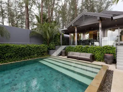 a swimming pool in front of a house at Infinity Blue Phuket by Elite Havens in Natai Beach