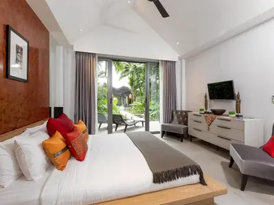 a bedroom with a large bed and a living room at Infinity Blue Phuket by Elite Havens in Natai Beach