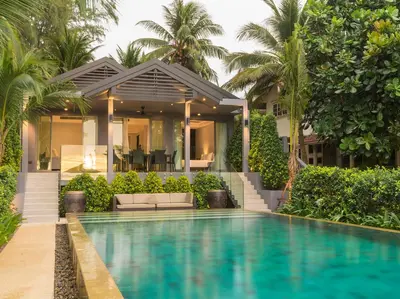 a house with a swimming pool in front of a house at Infinity Blue Phuket by Elite Havens in Natai Beach