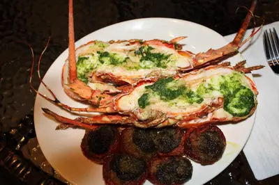 a plate of food with a lobster and broccoli at Hi Karon Beach in Karon Beach