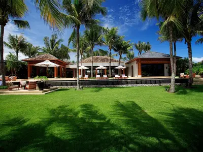 a house with palm trees in front of a yard at Villa Nandana by Elite Havens in Natai Beach