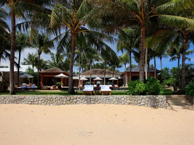a resort with palm trees and tables and chairs on the beach at Villa Nandana by Elite Havens in Natai Beach
