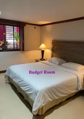 a bedroom with a large bed with a white bedspread at Le Tanjong House in Patong Beach