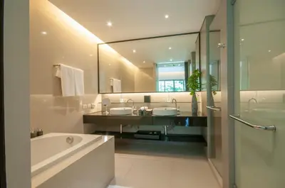a bathroom with a tub and a sink and a mirror at Thanyapura Sports & Health Resort in Thalang
