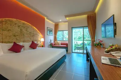a bedroom with a bed and a desk with a laptop at Thanyapura Sports & Health Resort in Thalang